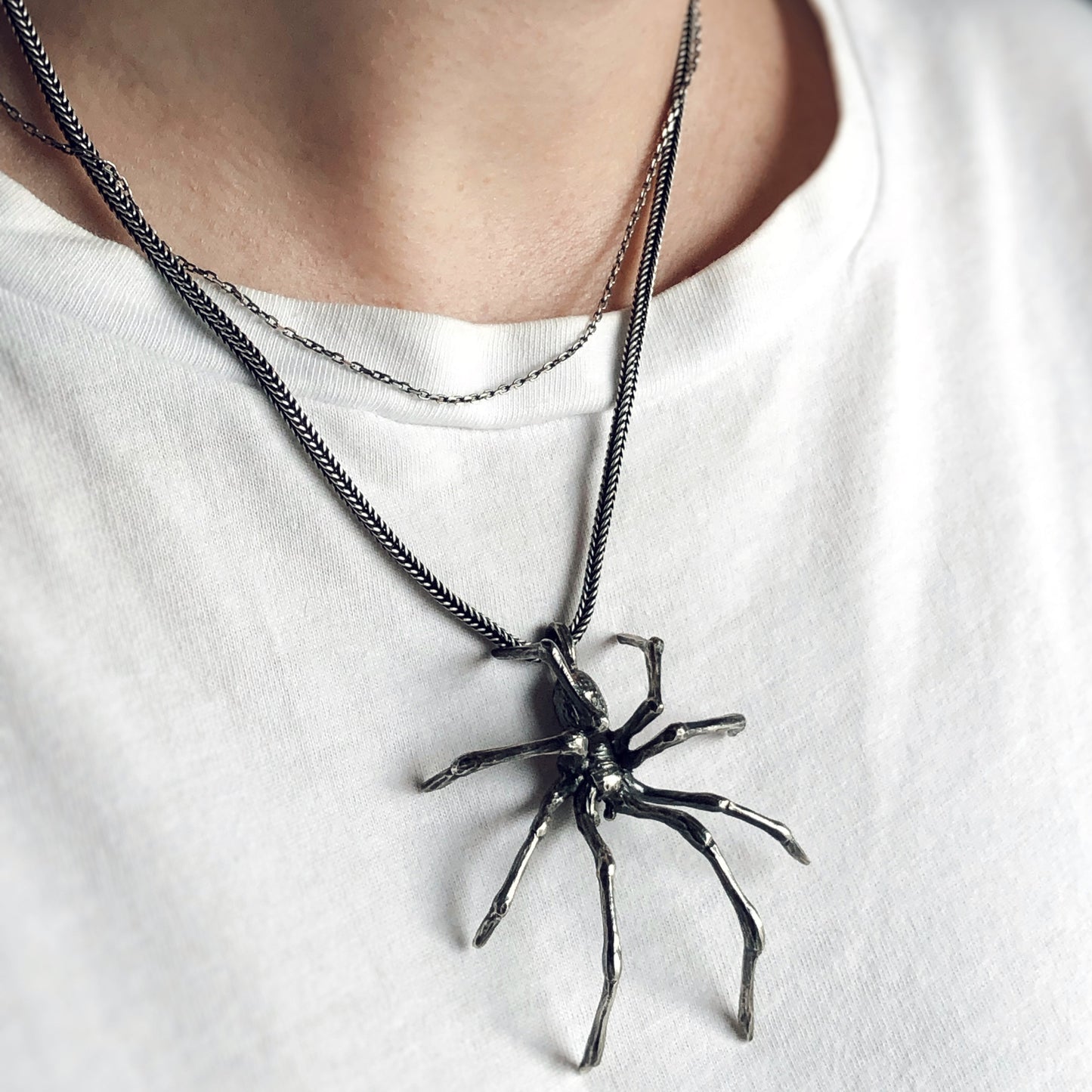 Oxidized silver spider pendant worn on a white t-shirt, bold and sculptural, part of gothic and oddities jewelry